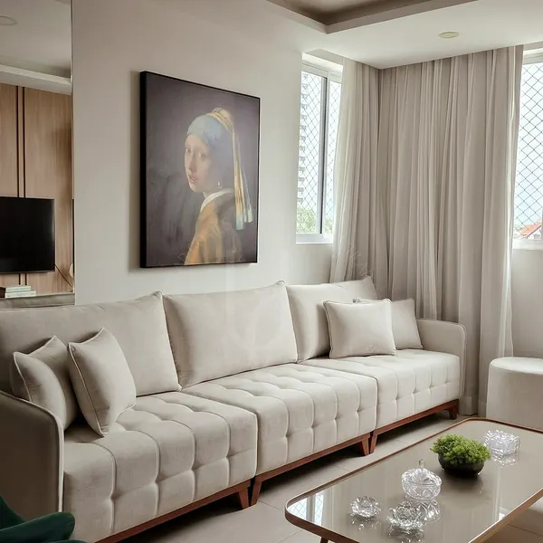 Sofá claro com assento capitonê em sala com quadro grande