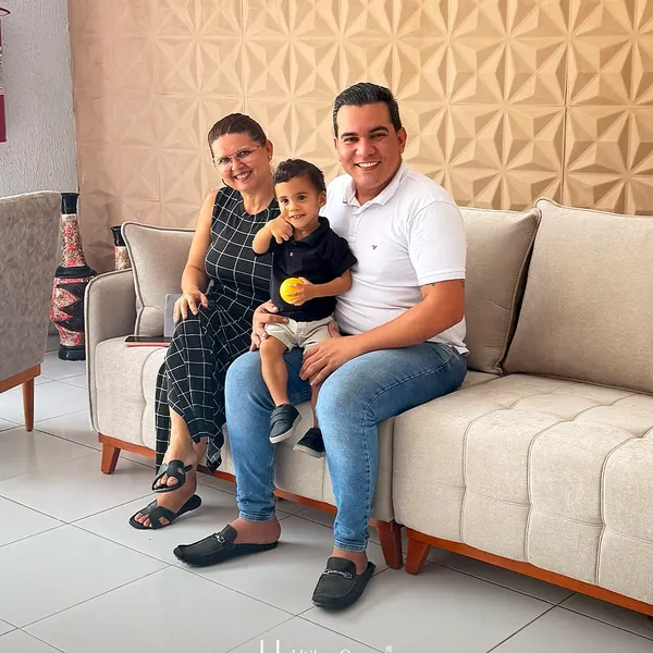 Família sentada em sofá bege da Utilar Gomes